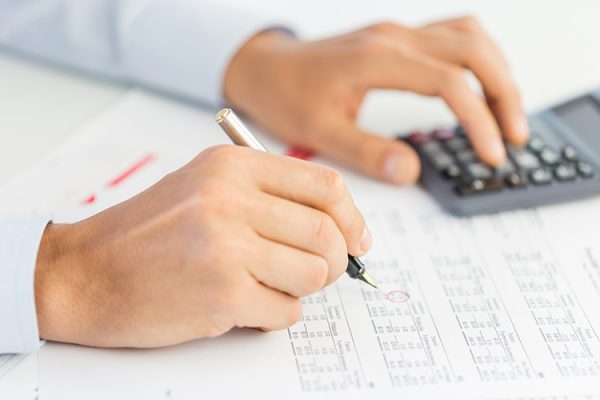 hands using calculator and writing on a form