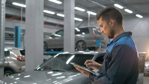 Man in auto repair shop using tablet computer