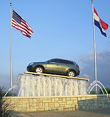 car displayed on platform above fountain